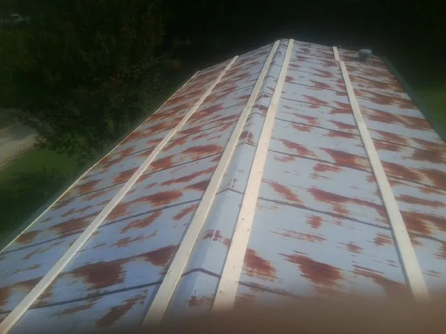 Rusted metal roof panels with new wood purlins before replacement — Storm Damage Roof Repair in Ames by Roofing Brothers