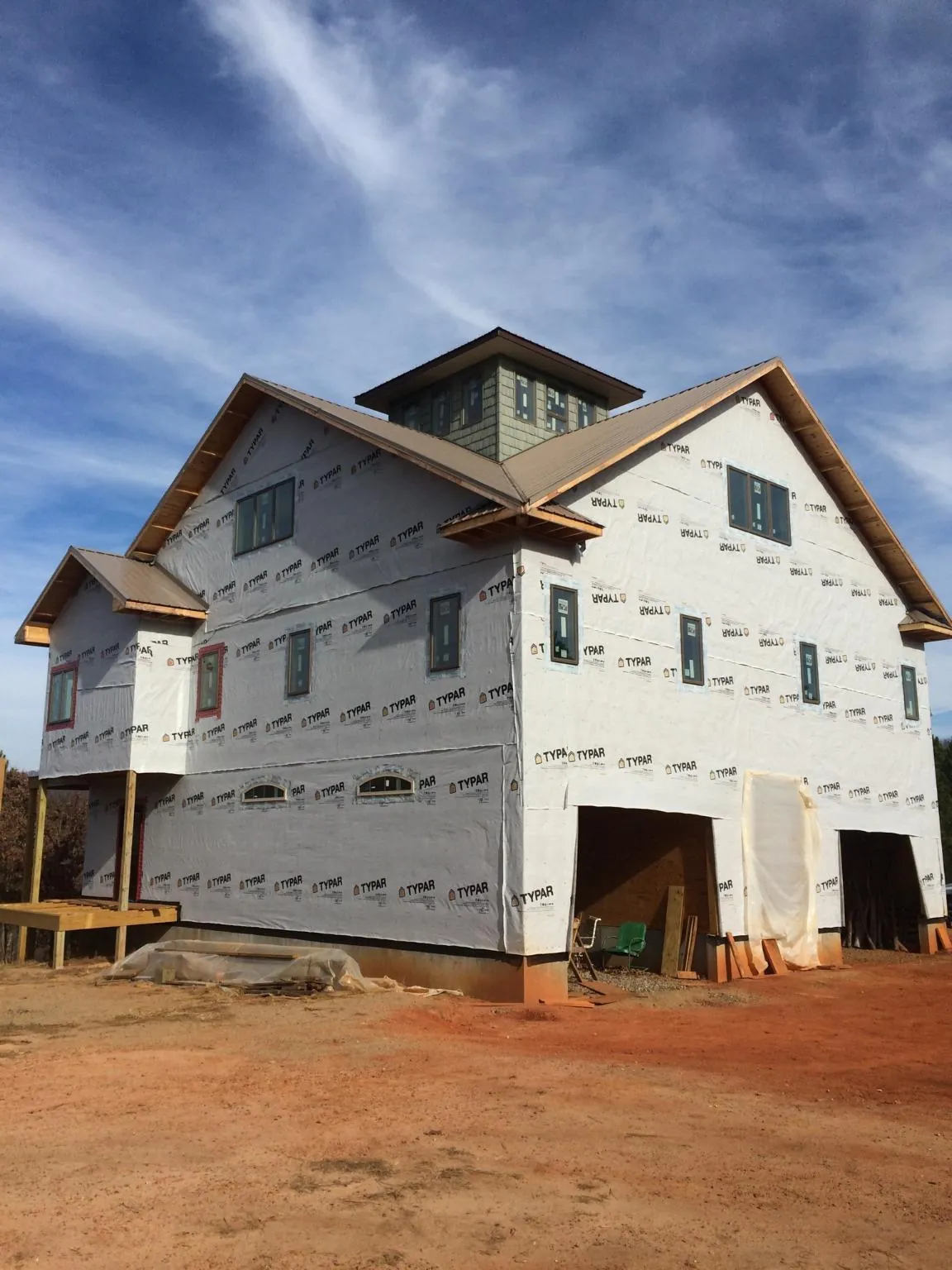 New two story house under construction with a cupola and gabled roofs in Ames